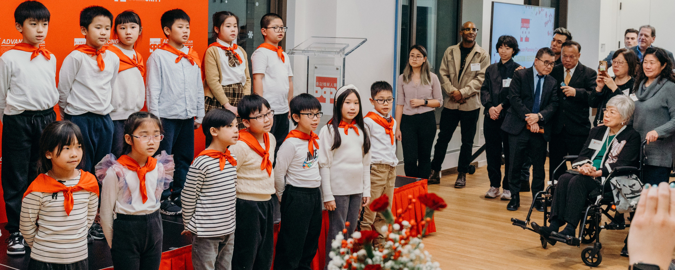 Group of children performing in front of an audience at a community event.