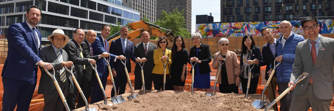 Board members smiling while holding shovels for a ground breaking event