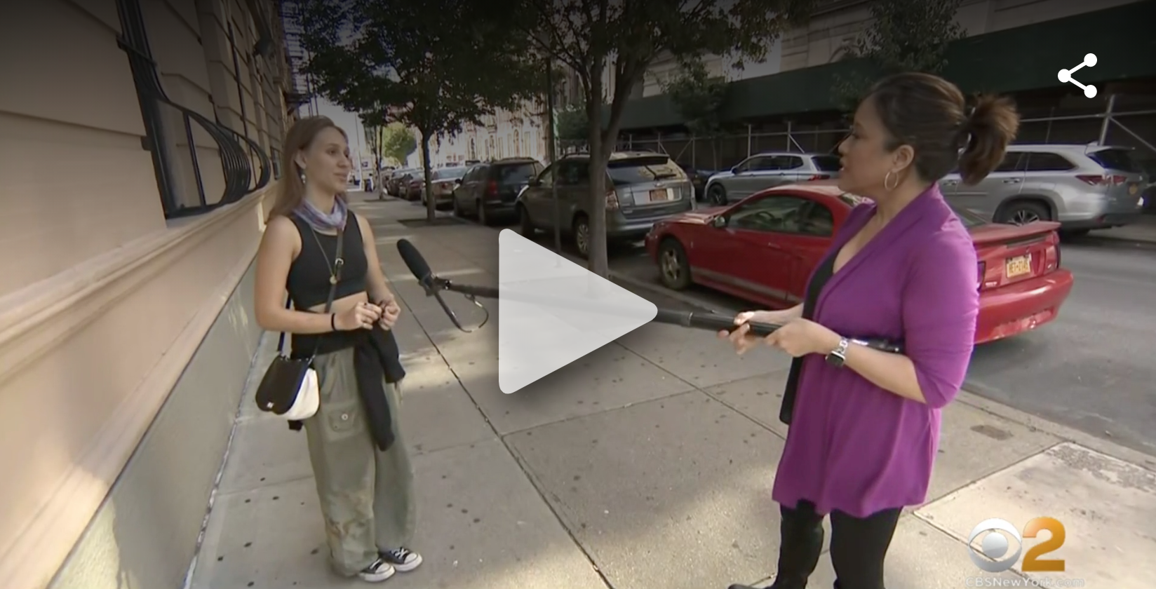 Levka is interviewed by a CBS reporter on the street using a long mic