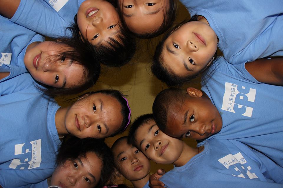 group of kids laying on the ground in a circle