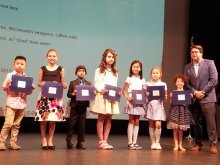 Anastasiia on stage with her certificate