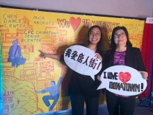 Kim To (left), Chief Development Officer, and Christina Wong (right), Assistant Director of CPC Chinatown Senior Center, pose in front of mural created for Chinatown Fire Relief Fundraiser